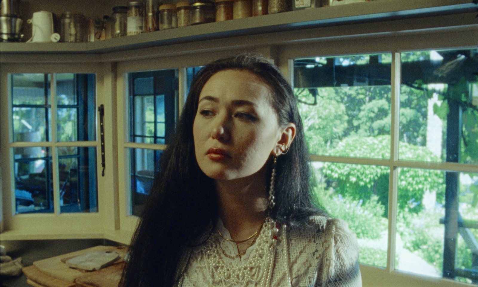 16mm still from the cigarette breakfast music video: dān dān in a kitchen of jars and windows