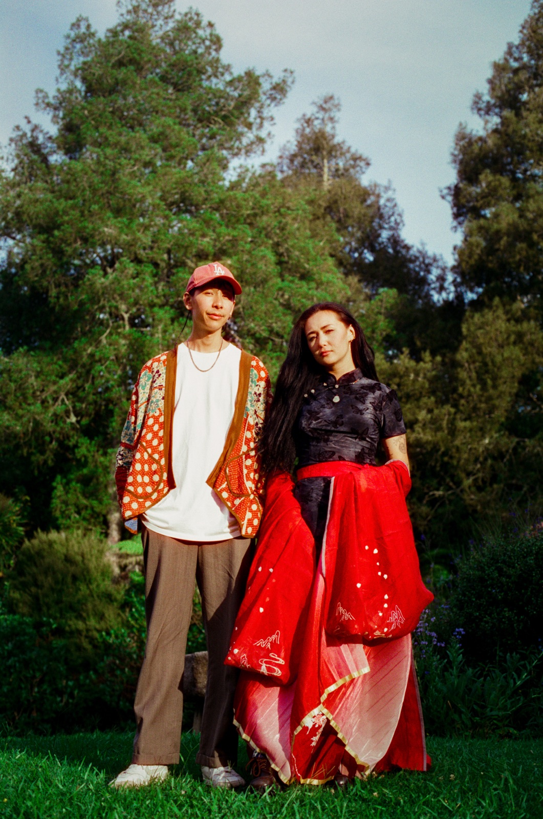 dān dān and Jefferson Chen stand together on a lawn in front of tall trees